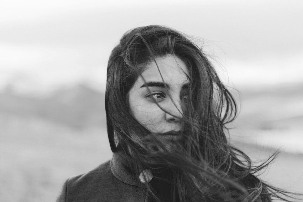 grayscale photography of woman covered her face with hair