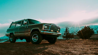 Suzuki Jimny parked with a scenic mountain backdrop near Medellín at sunset.