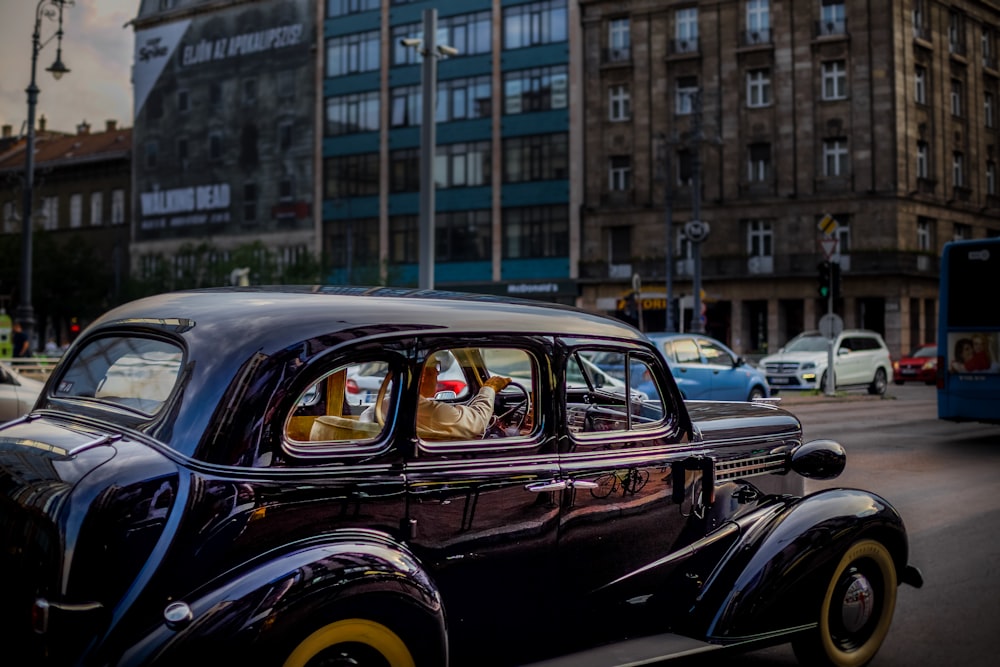 vintage black vehicle on road during daytime