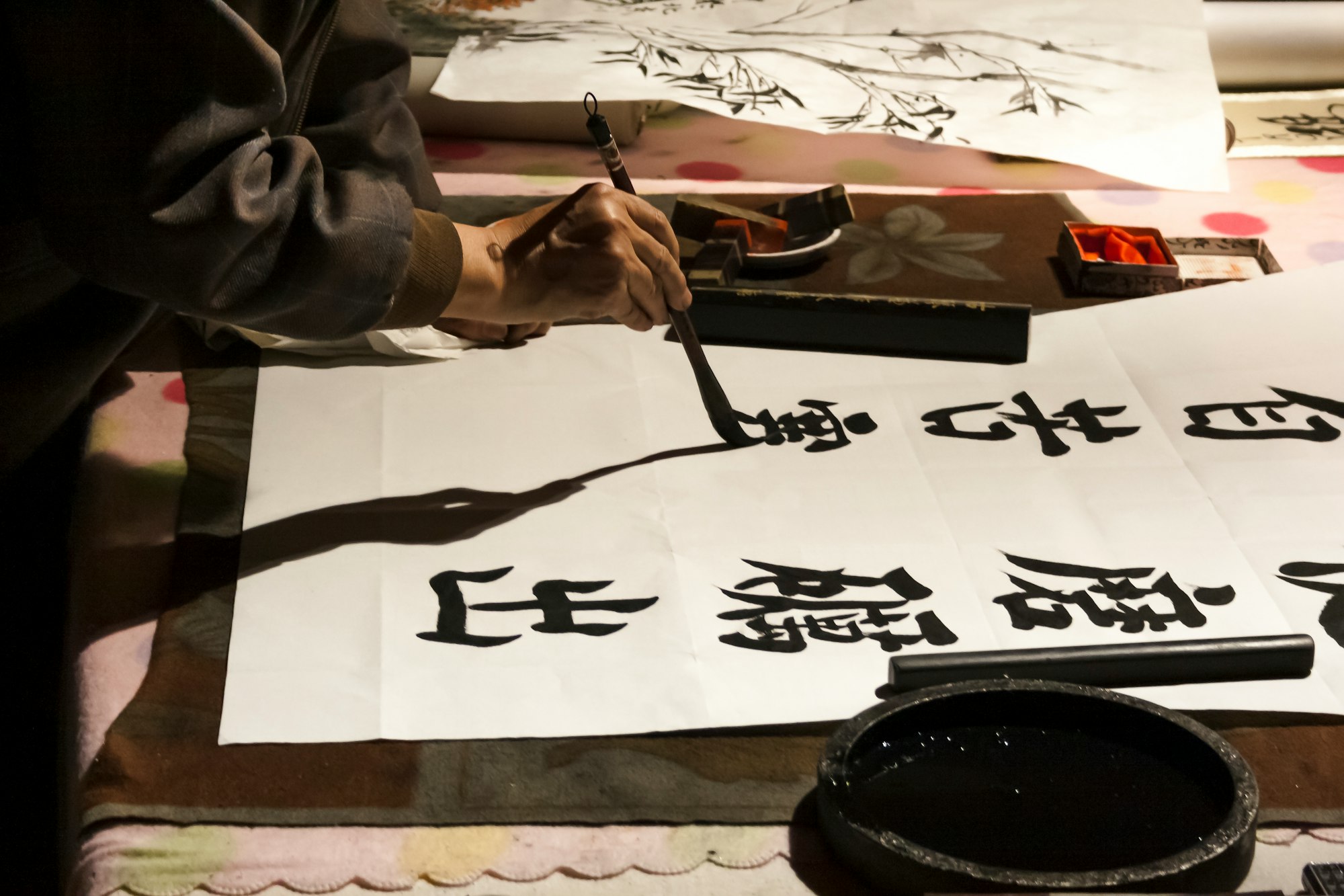Old men painting Chinese characters on paper rice 