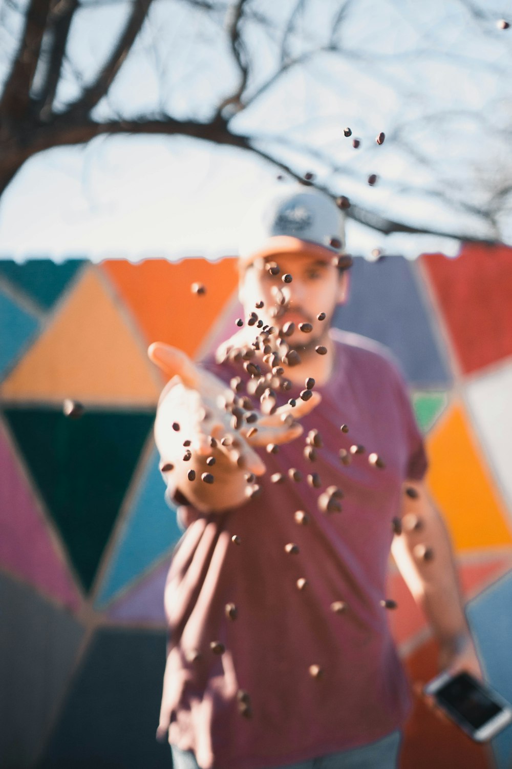 Photographie de mise au point d’un homme jetant des haricots vers l’appareil photo