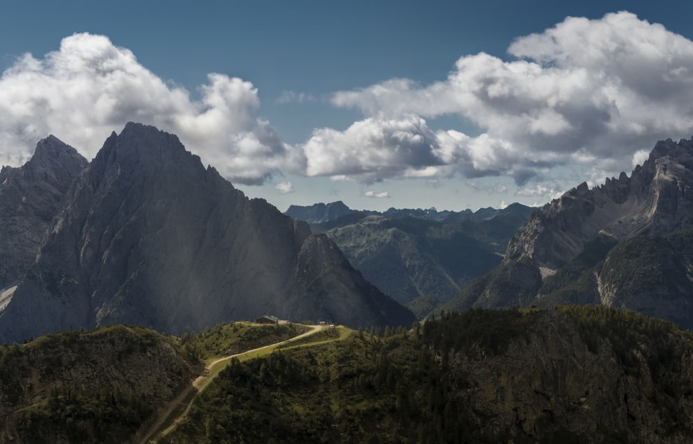 nature photography of rocky mountain under cloudy blue sky during daytime