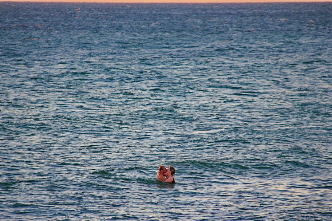 man and woman kissing on sea