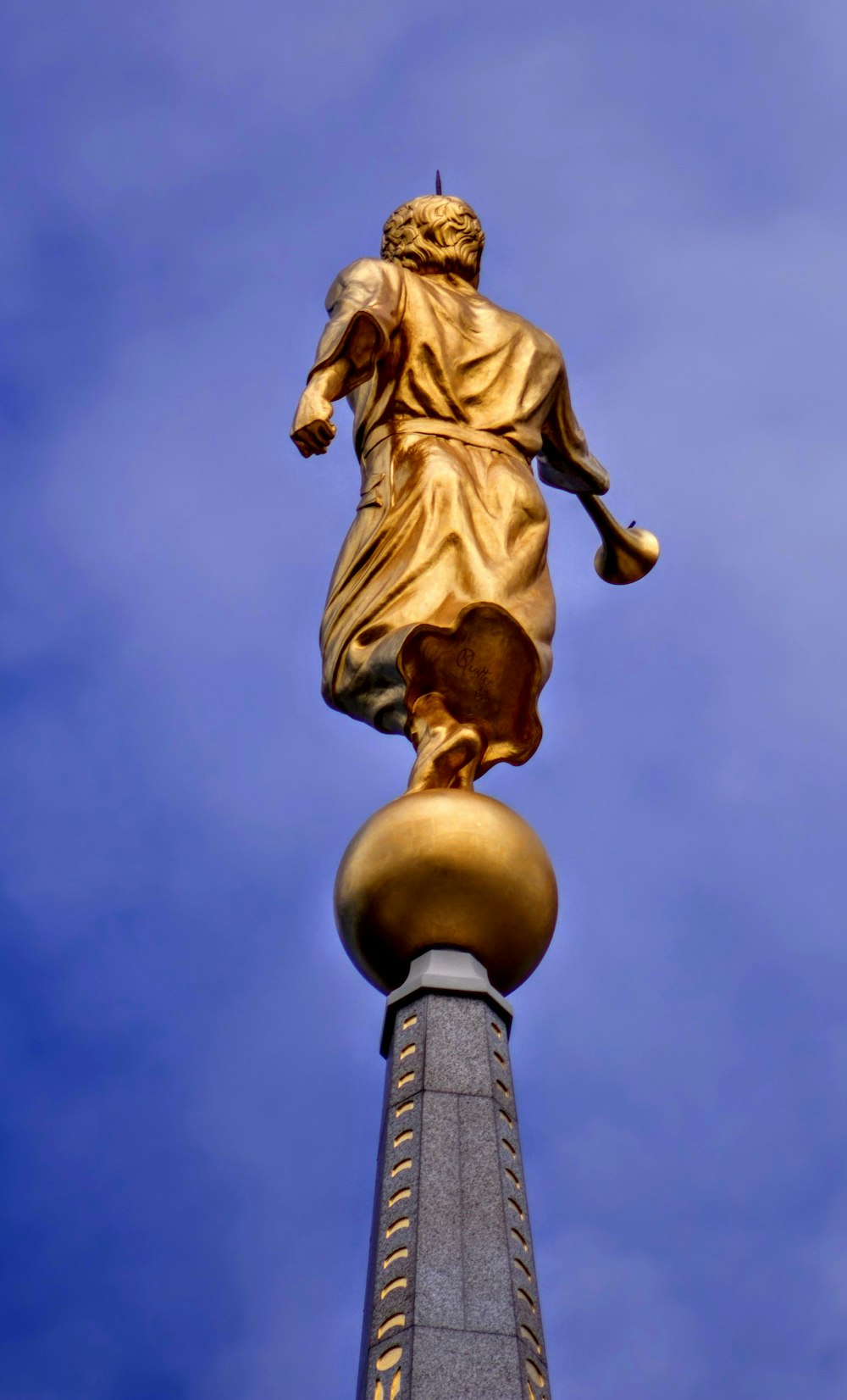 low-angle photography of man statue under clear blue sky