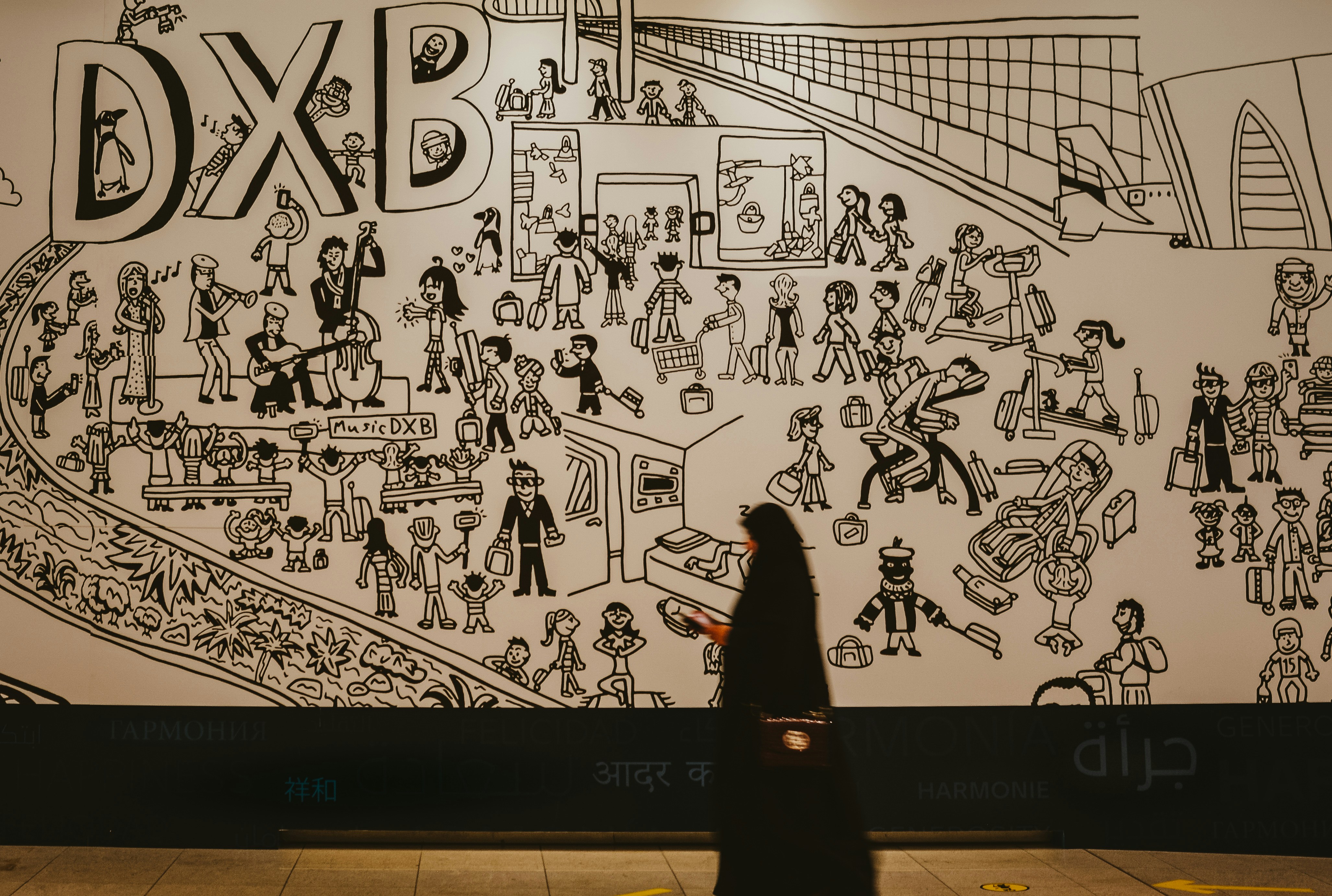 A Muslim woman walking past a wall art at Dubai (DXB) International Airport. Added tag for International Women’s Day 2019.
