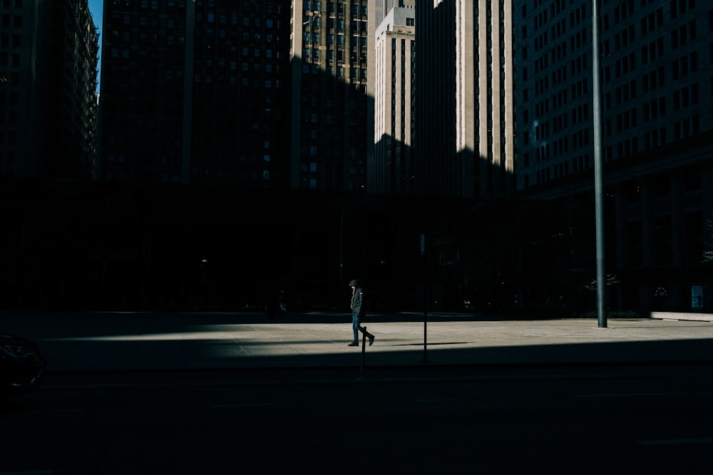 person walking on street near highrise building