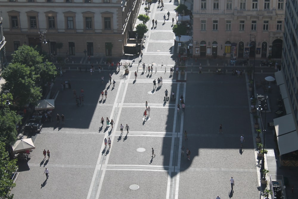 group of people walking on the road surrounded by buildings