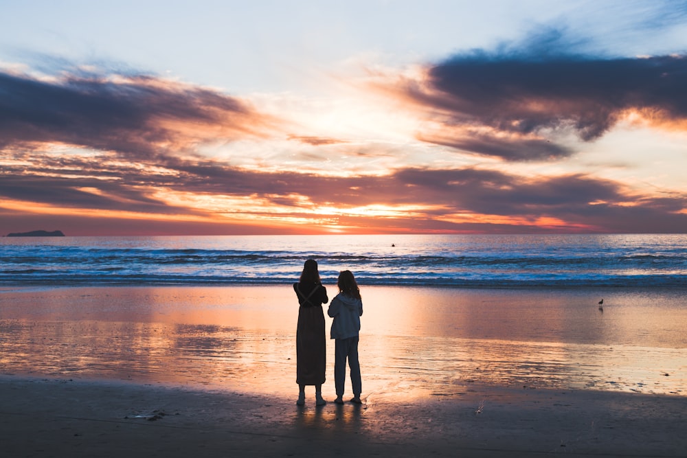 donna e ragazza in piedi sulla riva del mare