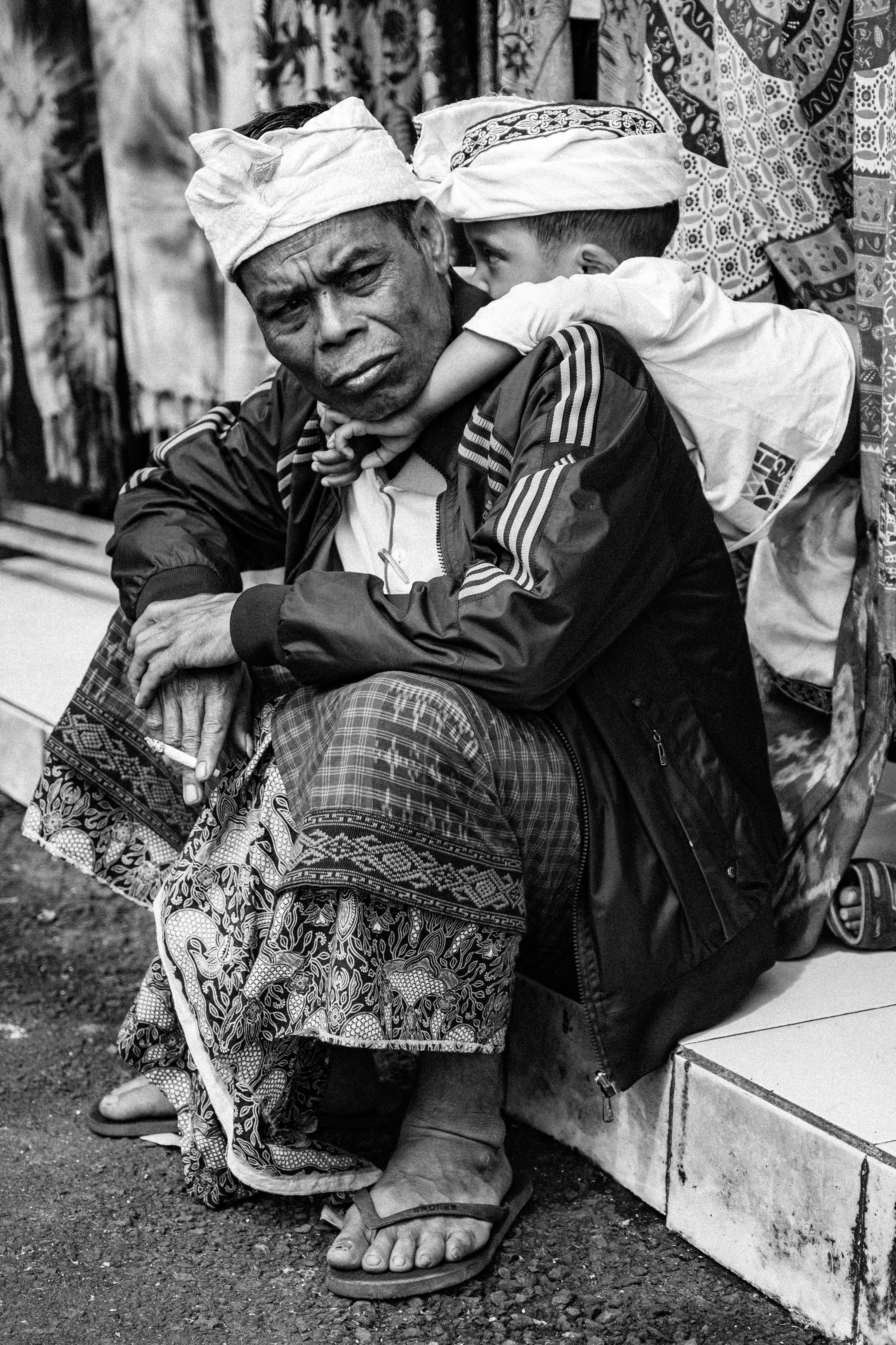 foto skala abu-abu pria duduk di lantai keramik