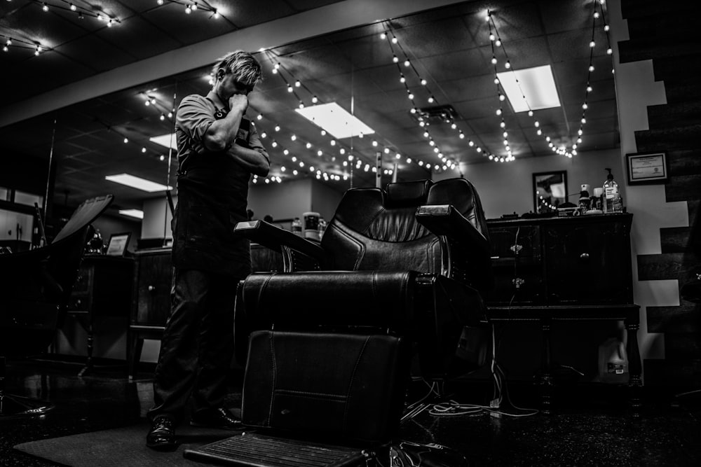 gray scale photo of man inside barber shop