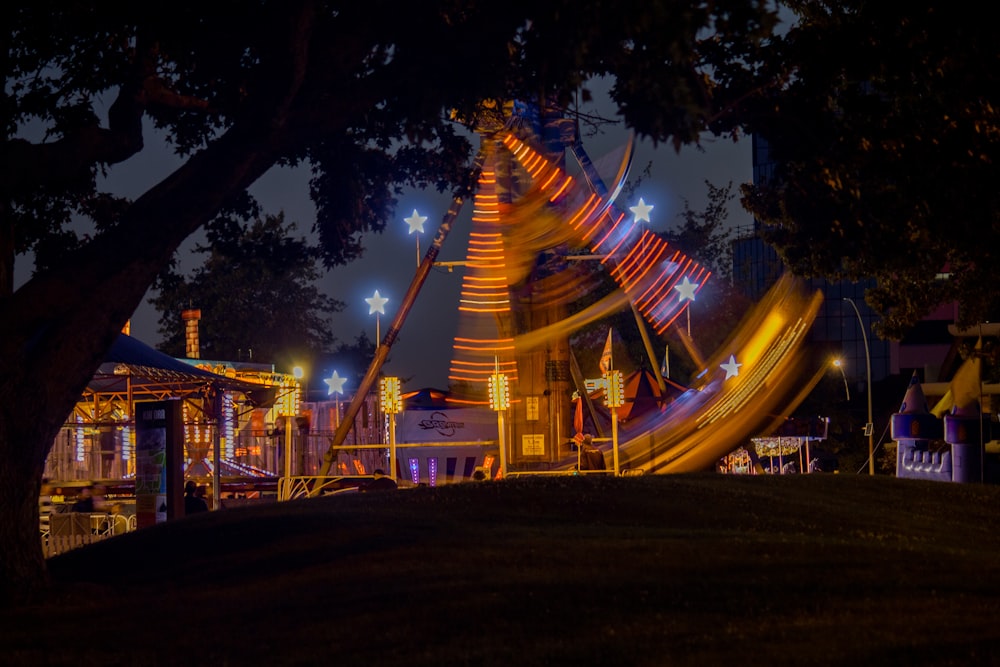 brown ferris wheel beside tree during night time