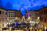 A lively city square filled with people enjoying a cultural festival at dusk.