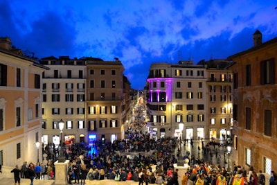A lively city square filled with people enjoying a cultural festival at dusk.