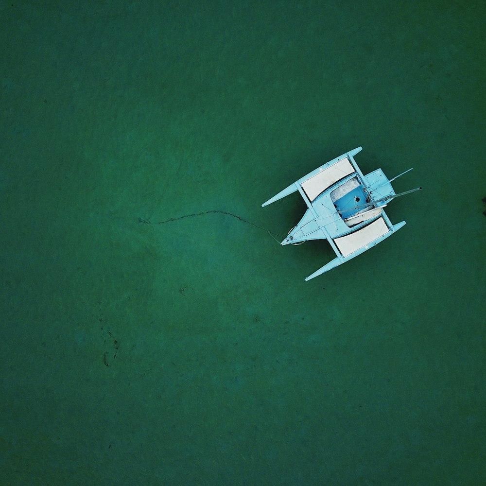 blue and white boat on body of water