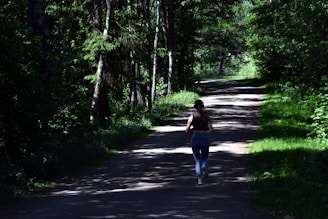 woman running near green trees