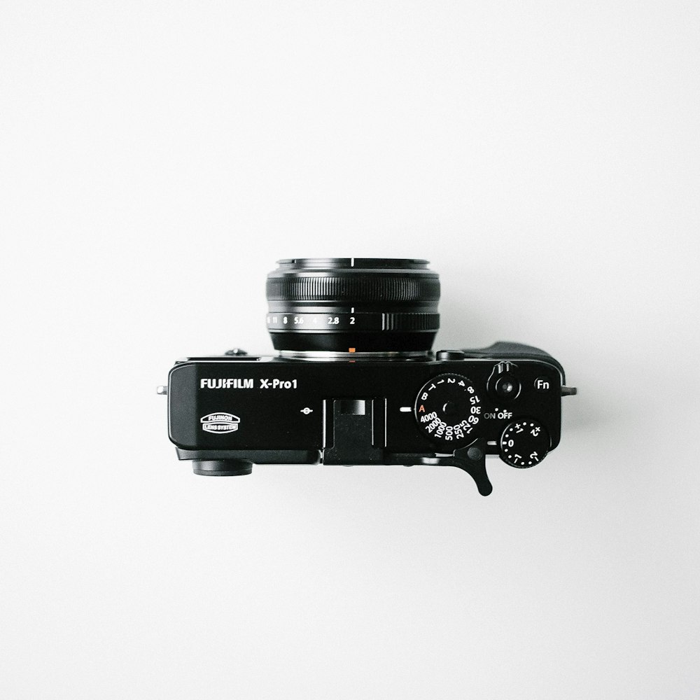 black Fujifilm compact camera on white background