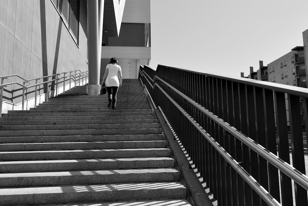 donna in scala di grigi che cammina al piano di sopra