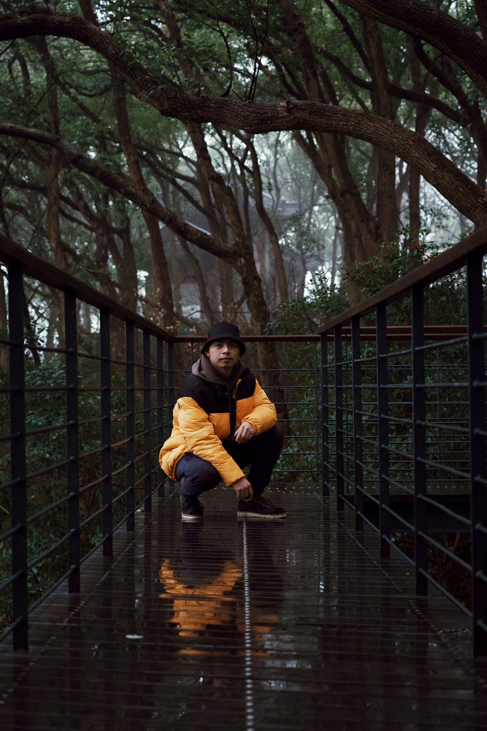 man wearing yellow jacket on bridge