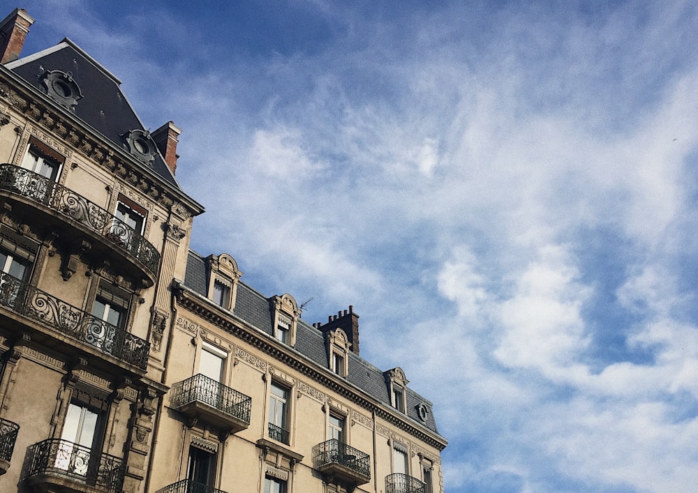 Weißes und schwarzes Betongebäude unter weißen Wolken und blauem Himmel während des Tages