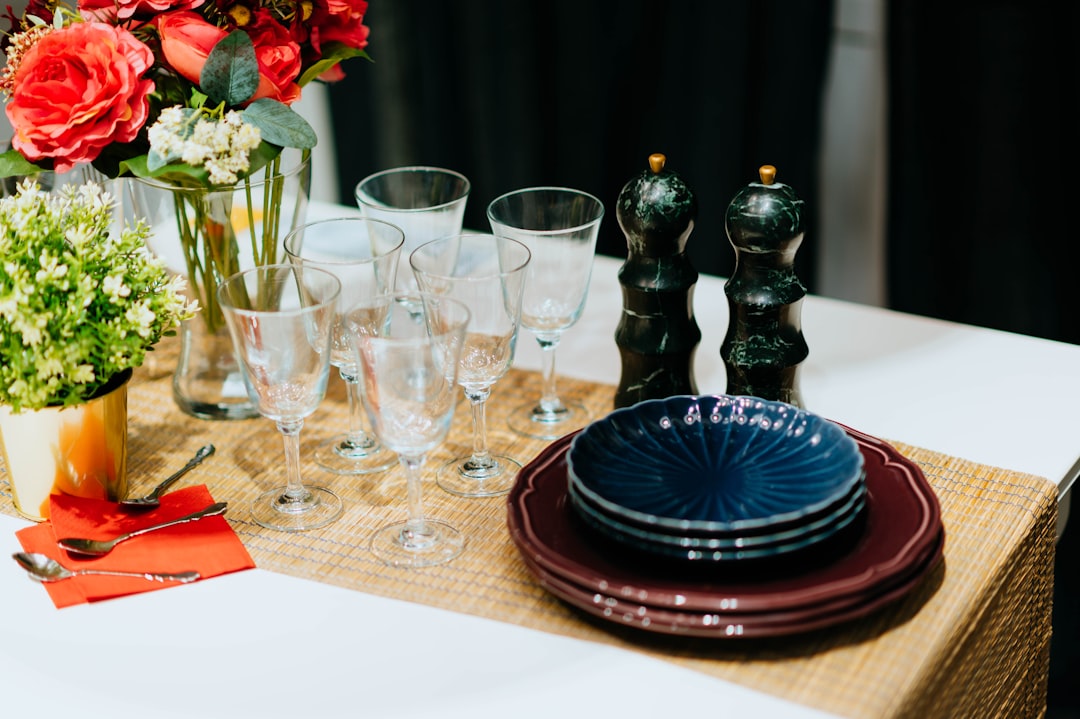 six clear long-stem wine glasses beside blue and brown saucers