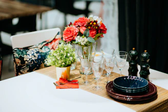 Decorative table setting featuring stylish souplats and elegant flower vases for a celebration.