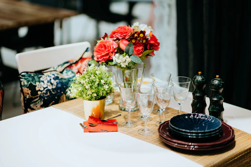 Decorative table setting featuring stylish souplats and elegant flower vases for a celebration.
