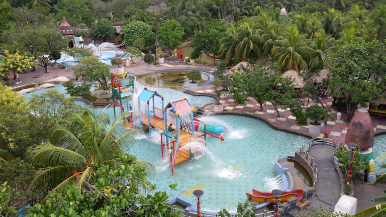 Family entertainment center featuring a volcano slide and rope course bustling with happy families.