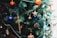 A beautifully decorated Christmas tree adorned with personalized ornaments in various colors.