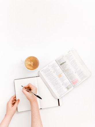 A student studying on a laptop at home with notes and a cup of coffee nearby.