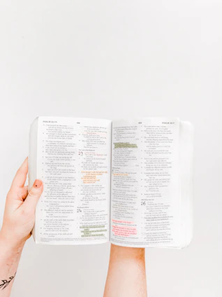 A close-up of hands flipping through the pages of a donation guidebook