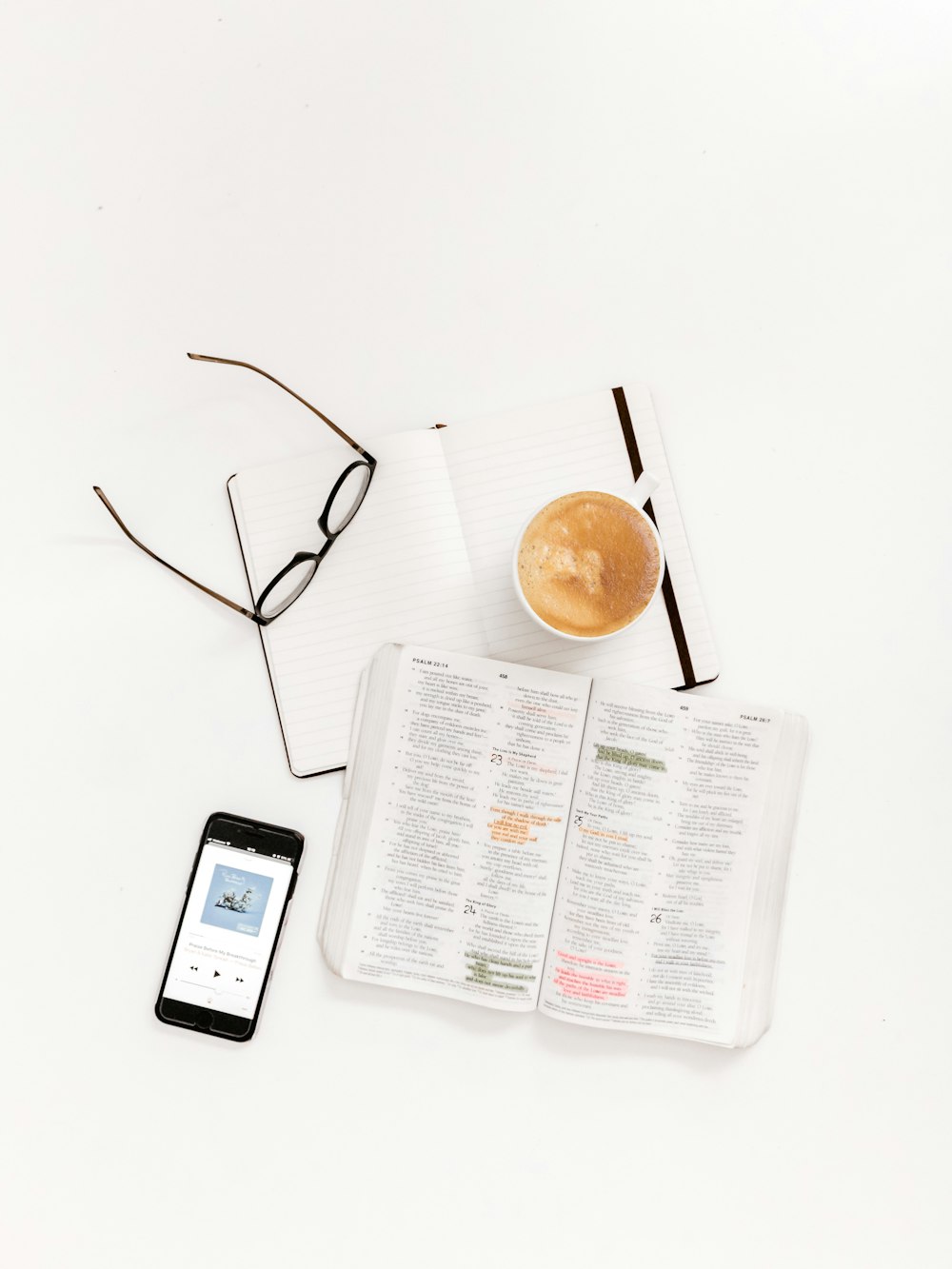 black framed eyeglasses, notepad teacup and smartphone