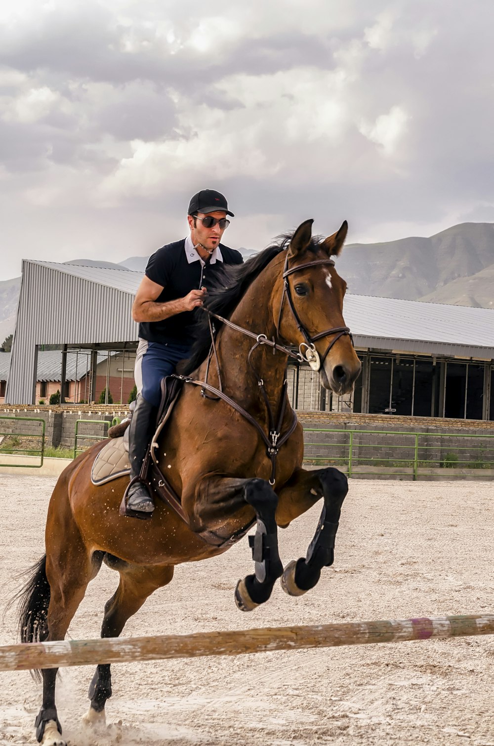 man wearing black cap riding brown horse