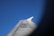 An airplane wing with visible registration markings is set against a clear blue sky. The photograph is framed in a way that features some dark, blurred edges resembling a vignette effect.