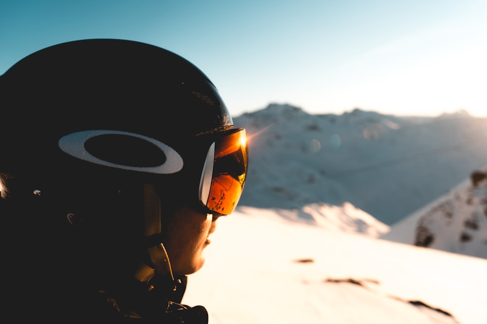 Man met helm en skibril op waar de zon in weerkaatst 