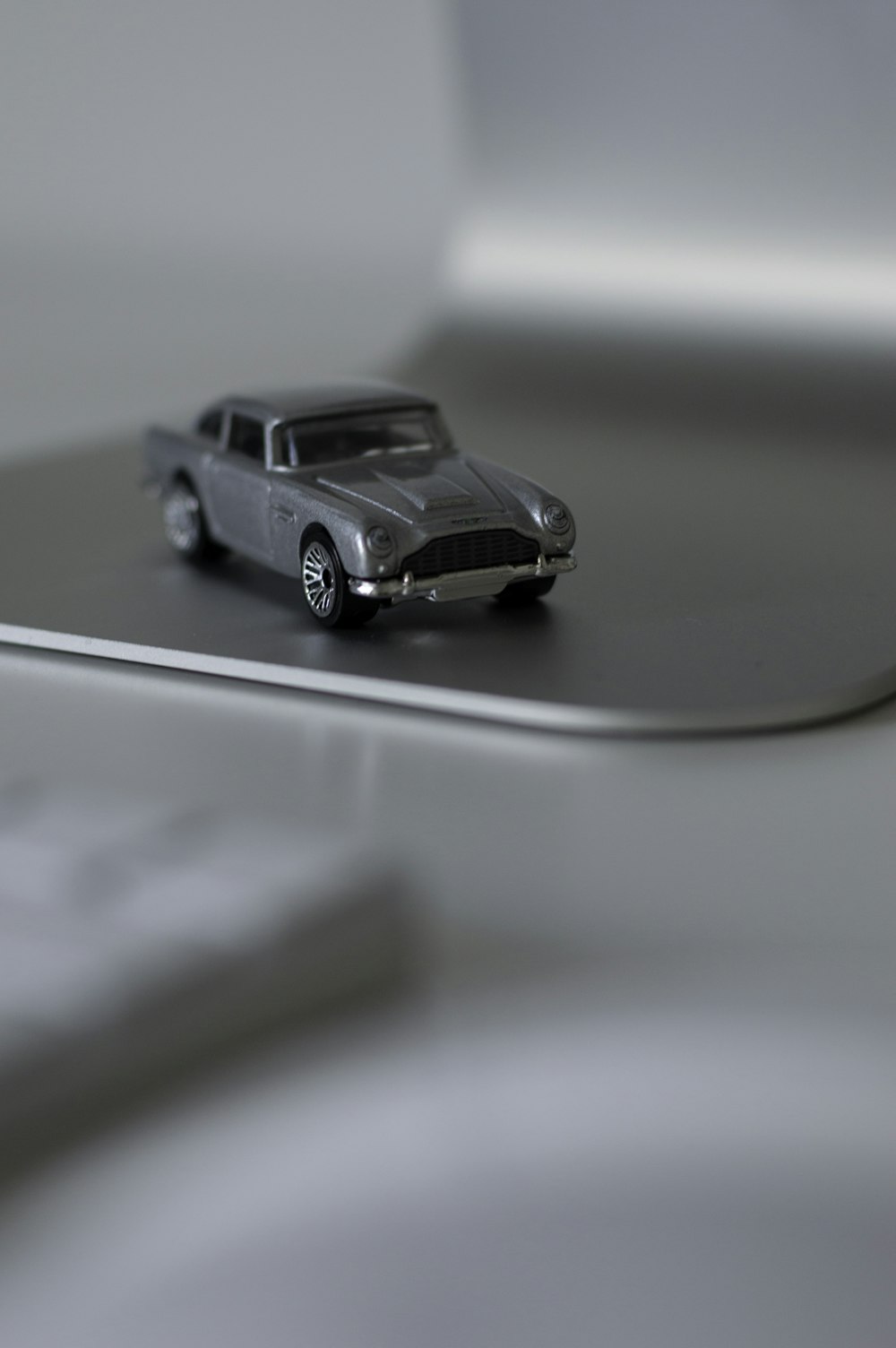 shallow focus photography of silver die-cast car model