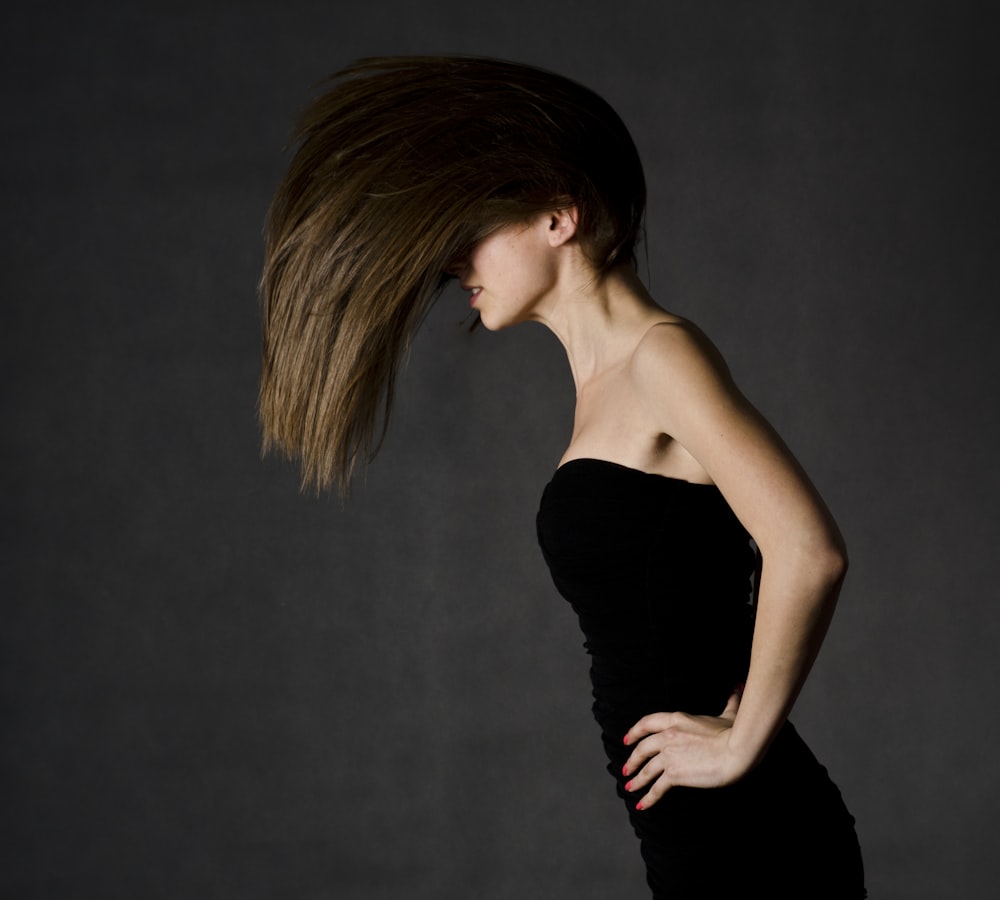 woman wearing black strapless dress holding on waist