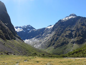 A crisp alpine scene with snow-capped peaks and rugged mountain paths.