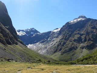 A crisp alpine scene with snow-capped peaks and rugged mountain paths.