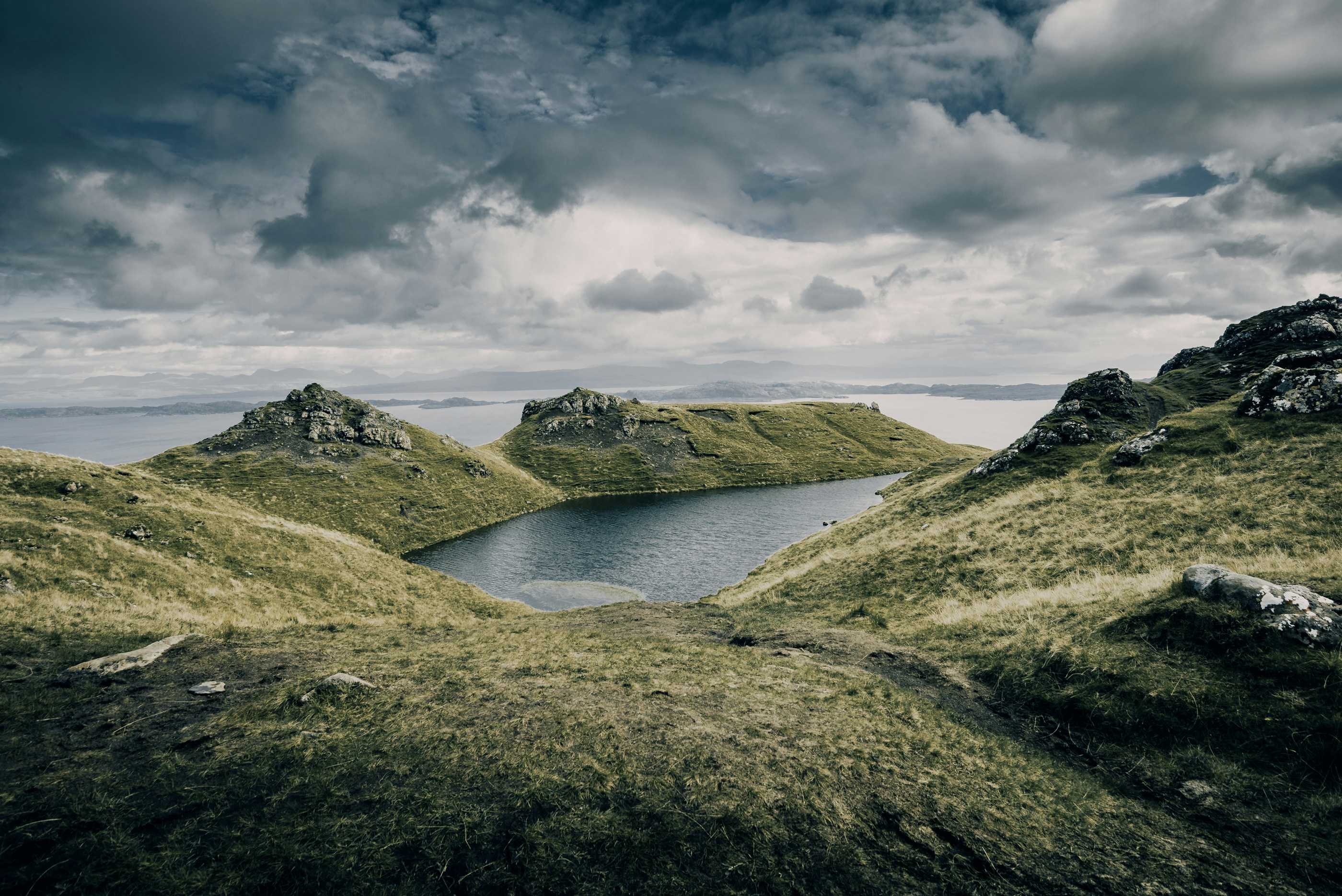 aerial photo of mountains under cloudy sky, Land of Lochs in Scotland