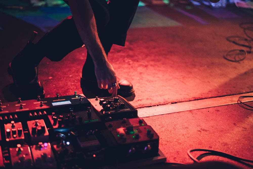 person holding guitar pedal