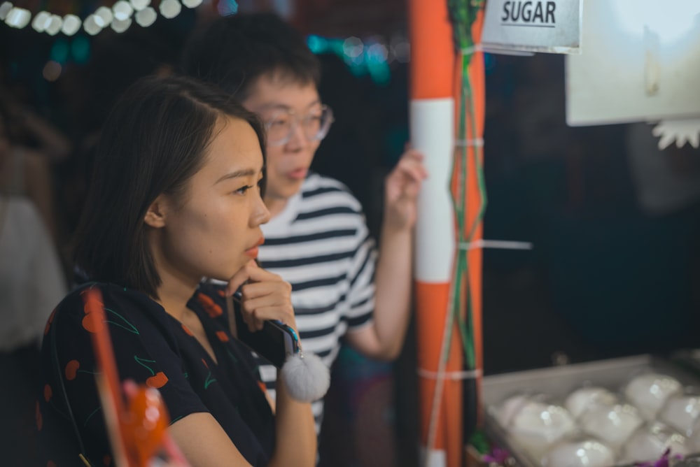 man and woman facing food stall