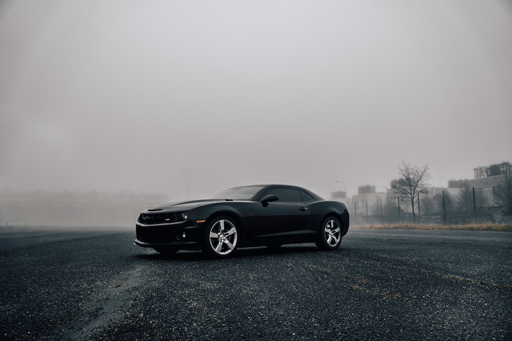 black Dodge Challenger on road during foggy day