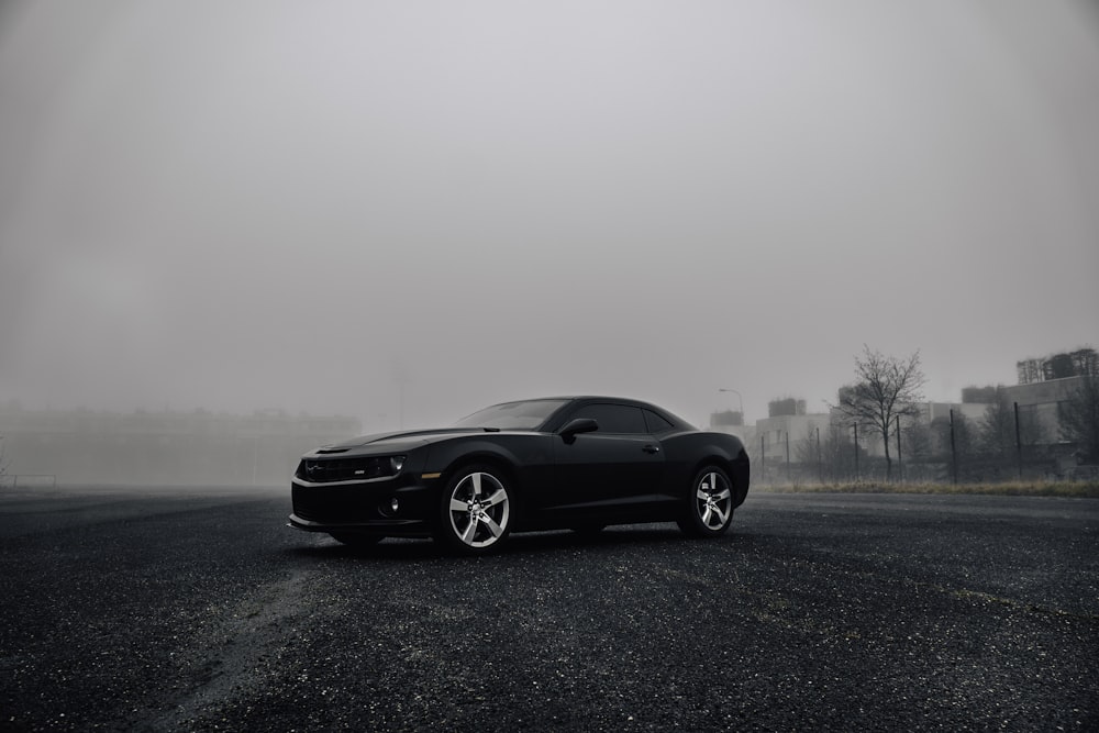 black Dodge Challenger on road during foggy day