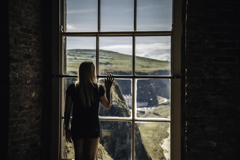 woman looking outside glass window