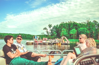A group of friends laughing together on a boat ride across a serene lake.