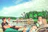 Group of friends laughing and enjoying a daytime boat party on a sunny lake