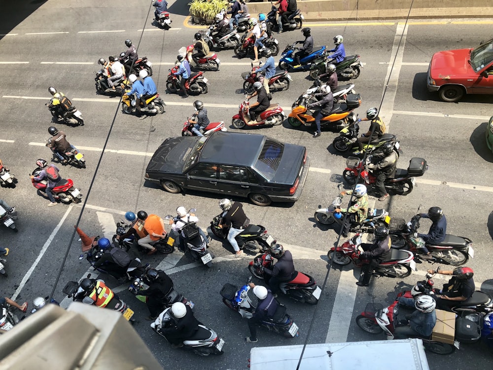 aerial view photography of black sedan surrounded by motorcycles