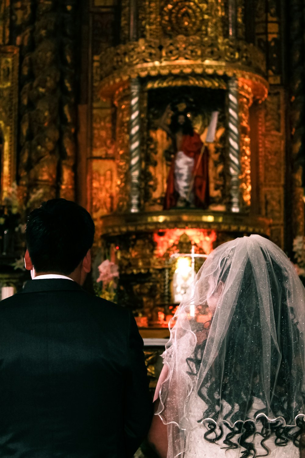 bride and groom facing alter