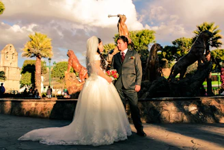 Bride and groom smiling while a wedding planner coordinates the event in a sunny Malaga garden.