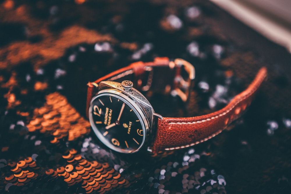 round silver-colored analog watch with brown leather strap